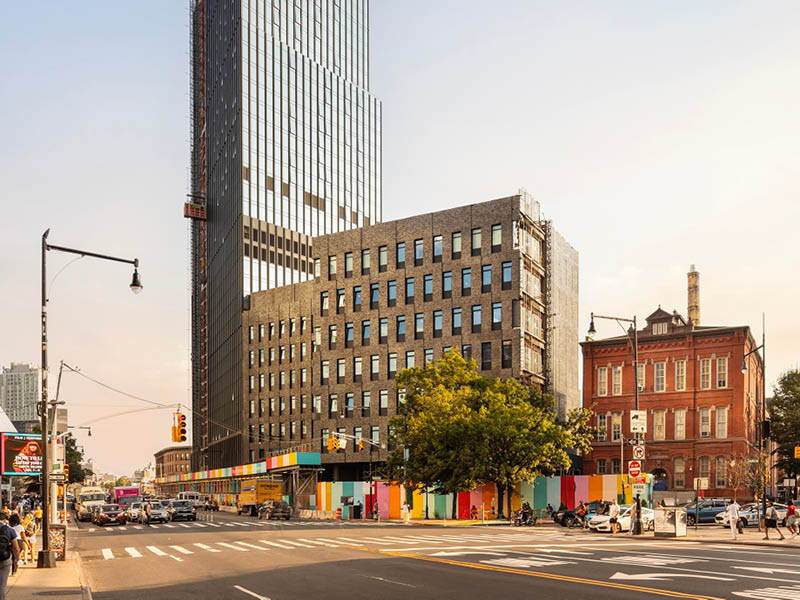 Photograph of the new public high school at 100 Flatbush under construction, showing street and traffic in the foreground