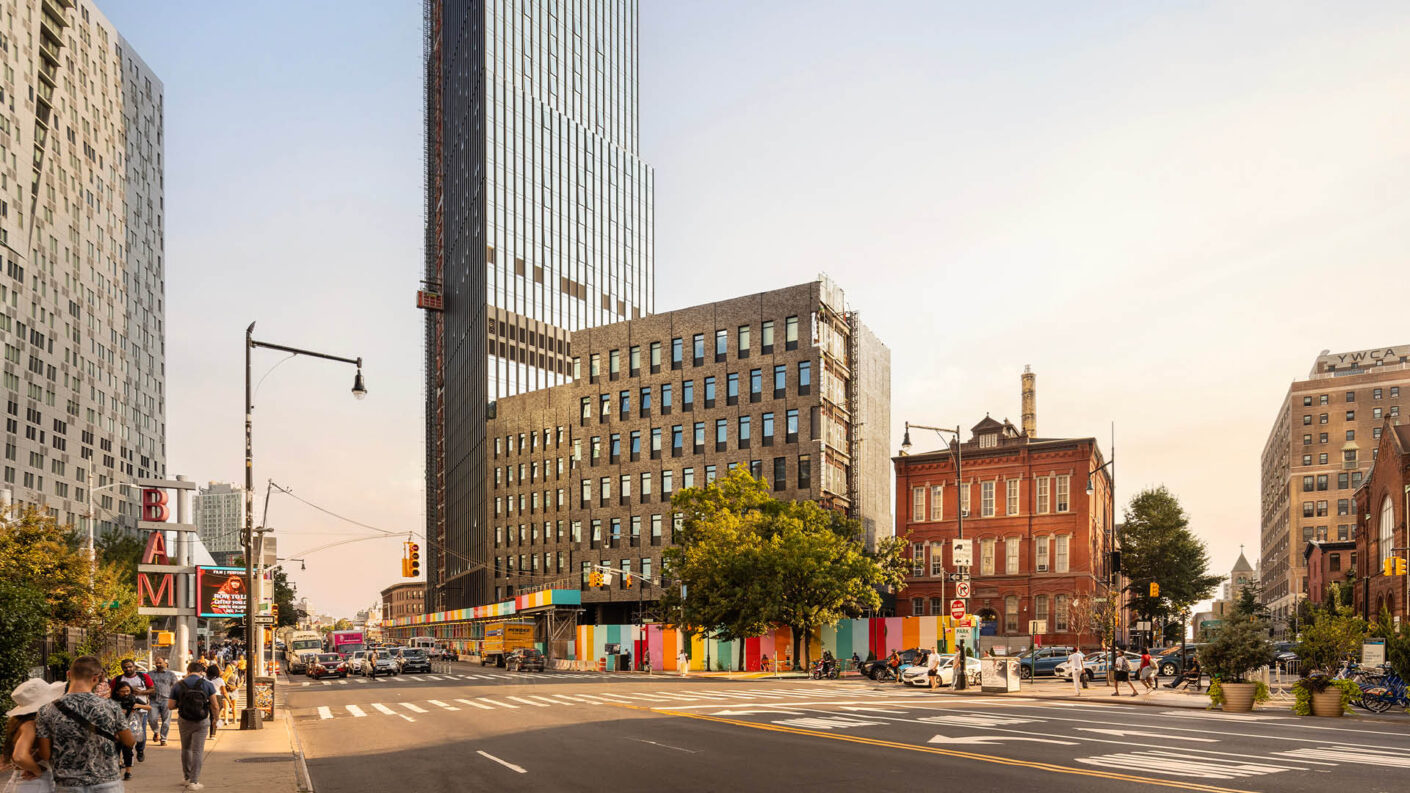 Photograph of the new public high school at 100 Flatbush under construction, showing street and traffic in the foreground