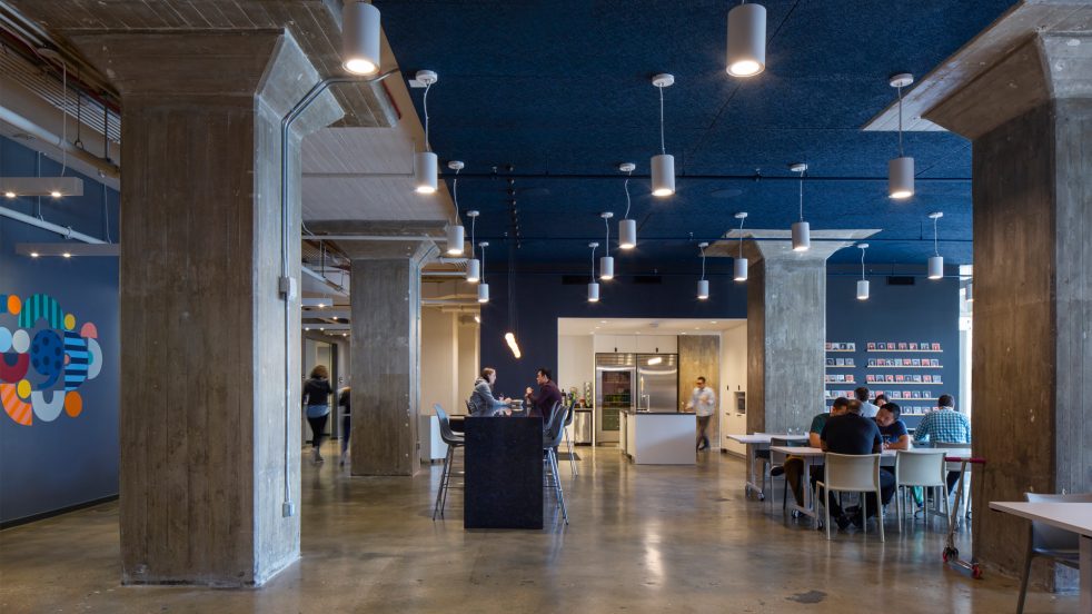 a cafeteria with blue accents doubles as informal meeting areas and includes a communal kitchen