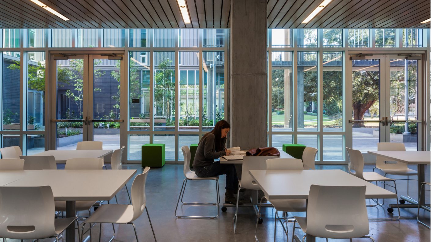 student studies in common area with access to the courtyard