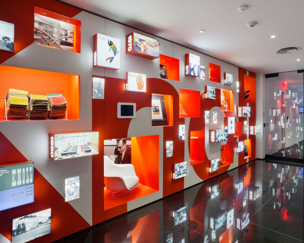 exhibition display of Knoll's timeline on a wall with Knoll written in an orange supergraphic