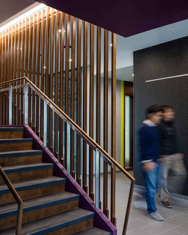 students pass by decorative staircase while exiting the Applied Math building