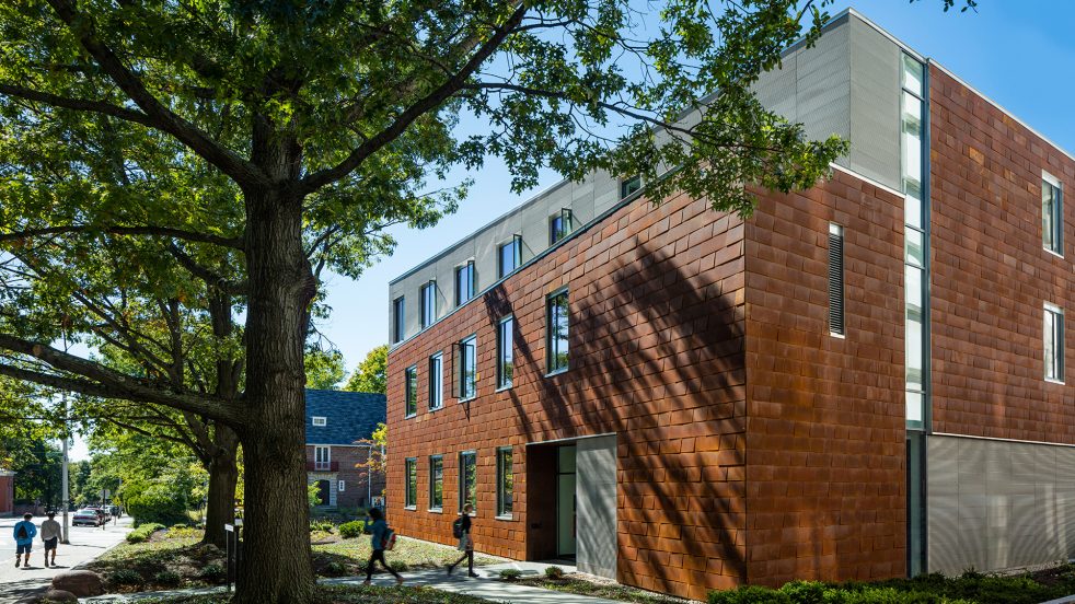 large trees and students entering along the residential-facing façade of the Applied Math building