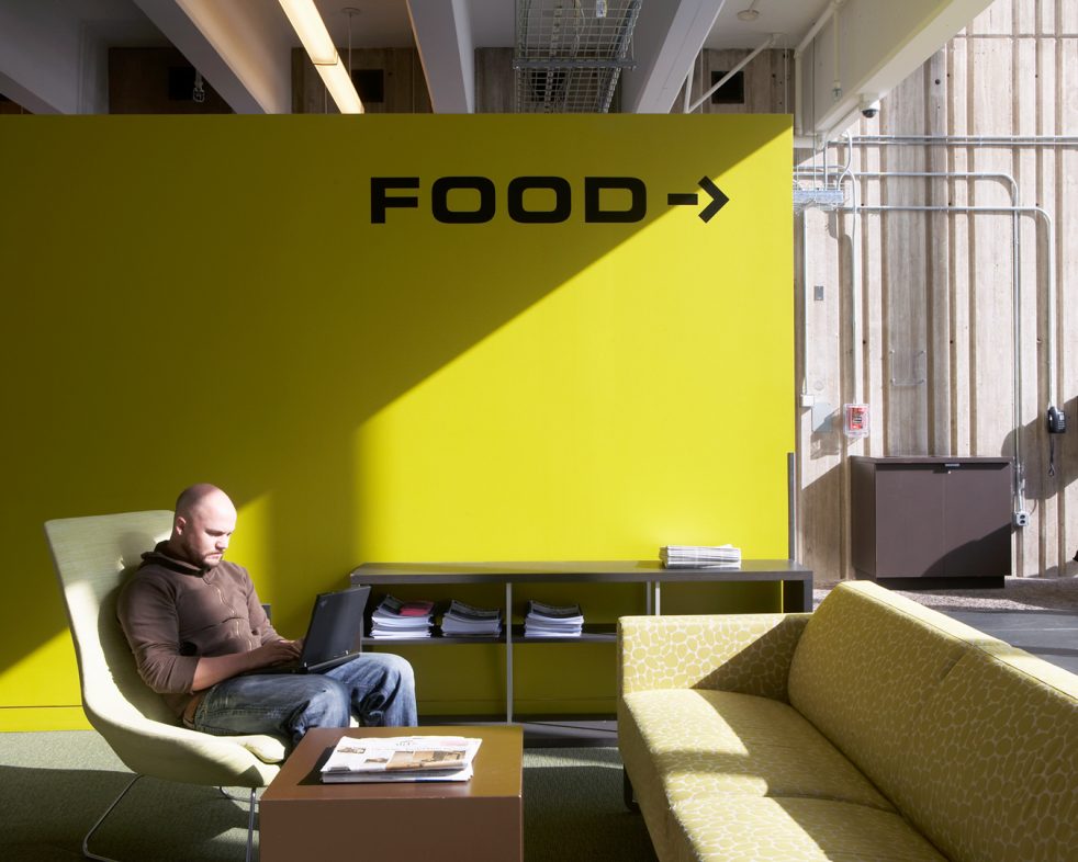 students studies in front of green wall with a graphic that reads 