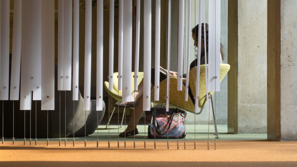 student reads behind dividers in lounge area