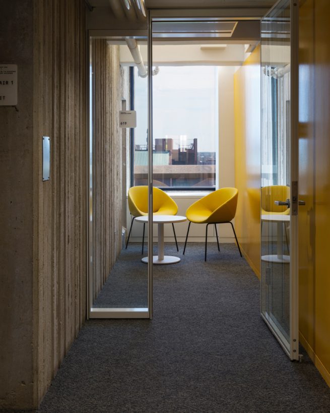 private study room with yellow chairs a large window and a yellow wall