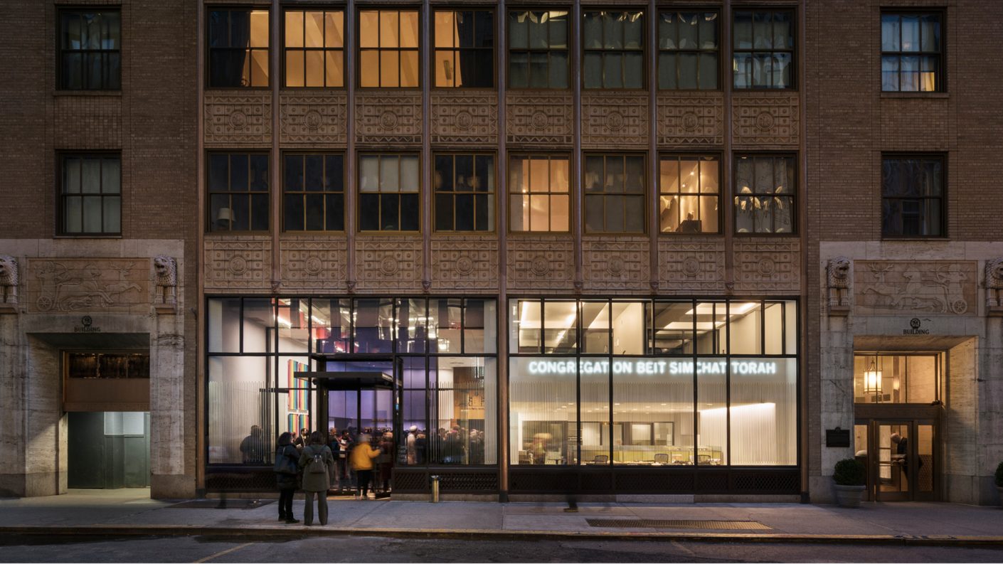 entrance to a full CBST at the base of a landmarked building illuminated at night