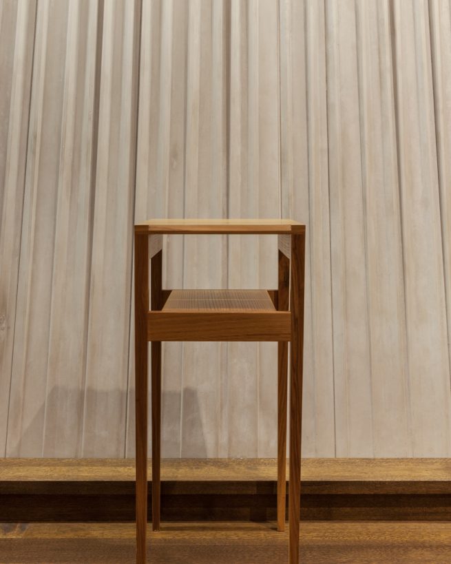 wooden table before the textured concrete sanctuary wall