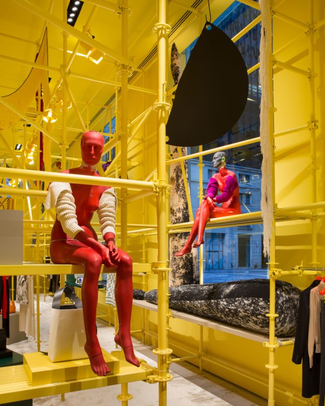 red mannequins sit among yellow scaffolding, Sterling Ruby art, andCalvin Klein collection, in yellow room