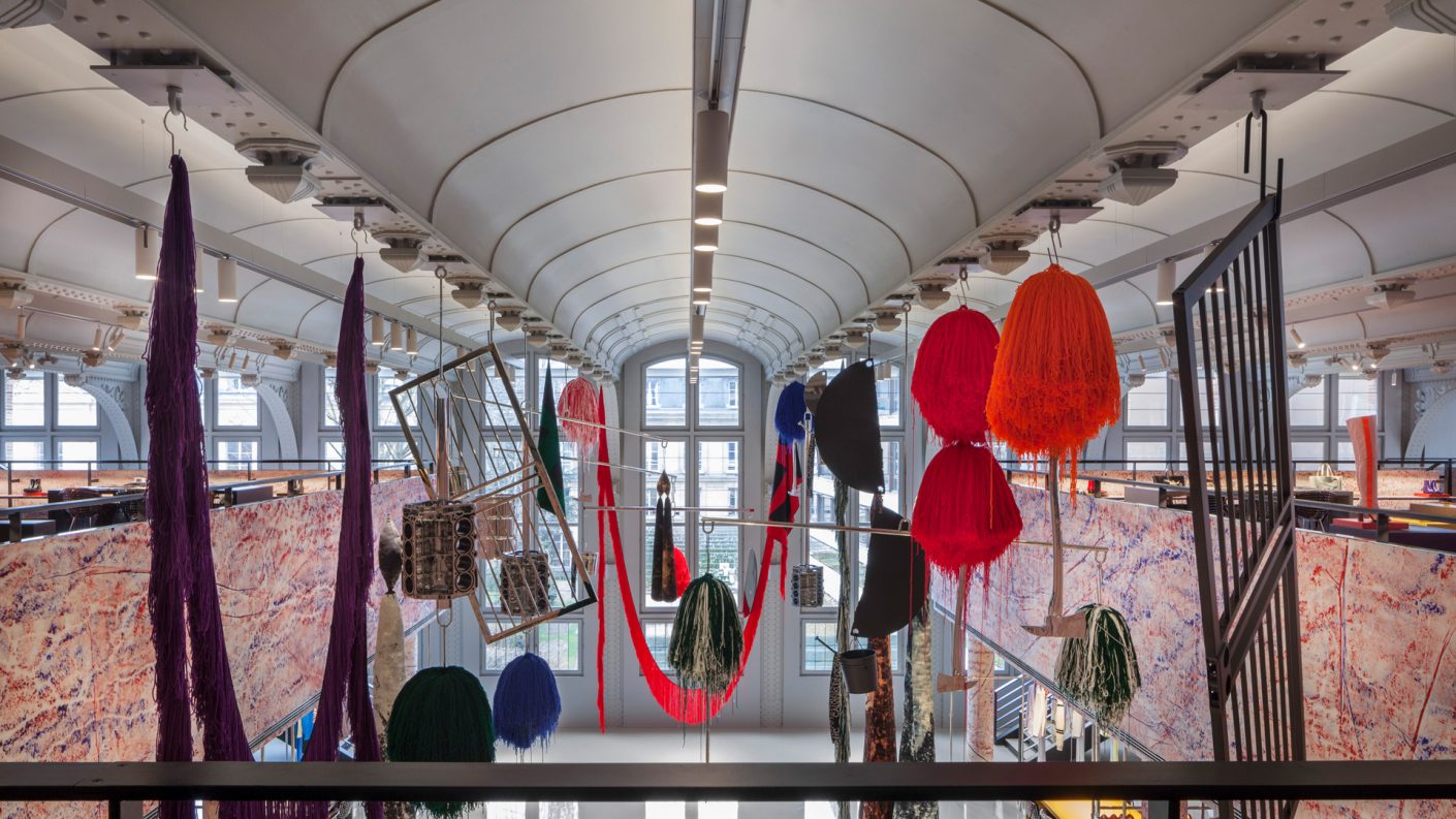 view of expansive space below a vaulted ceiling and through sterling ruby mobiles from mezzanine level