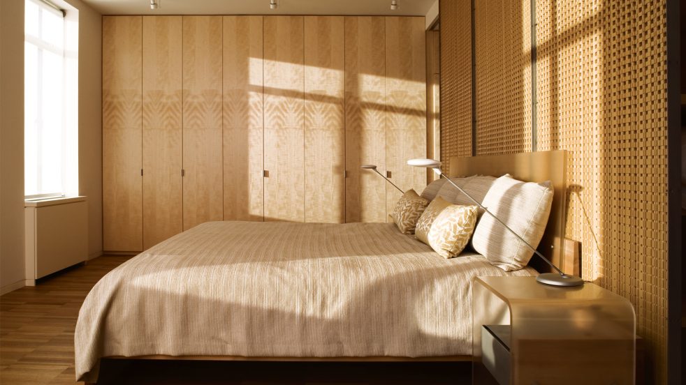 light casted onto bed in front of wooden screens