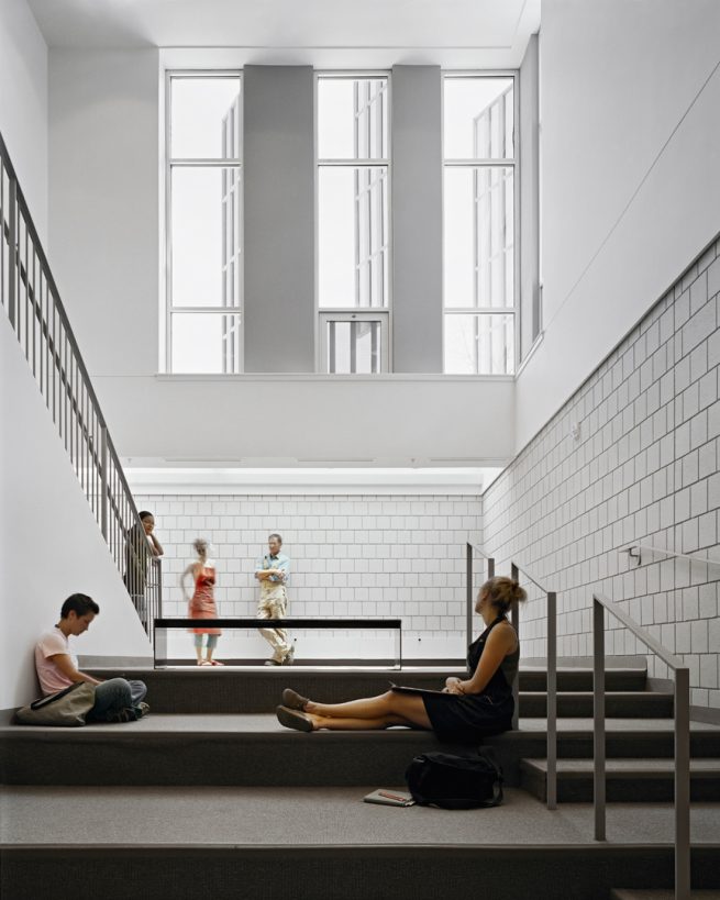 students lounge in two-story satir common area below windows