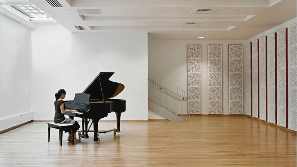 student practices piano below skylight