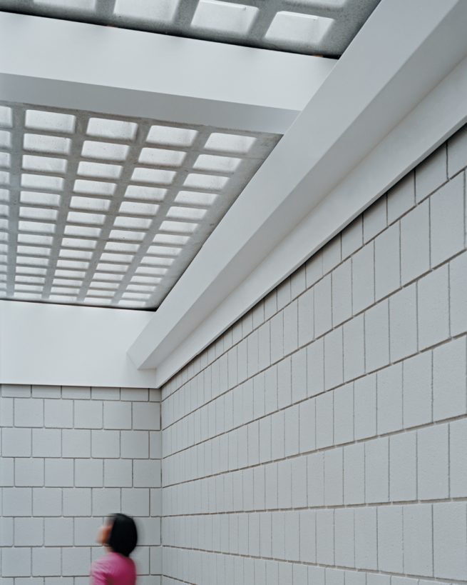 masonry interior with person looking up at skylights above