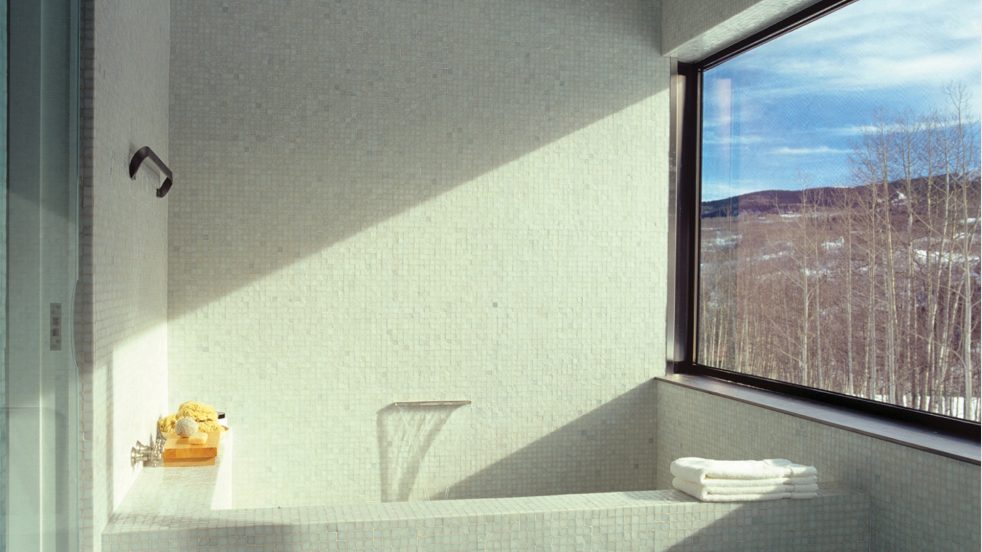 streak of light from a large window and view to snowy landscape from bathroom