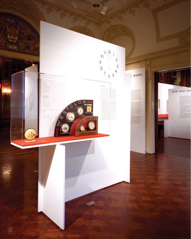 clocks exhibited in display case in front of text panel