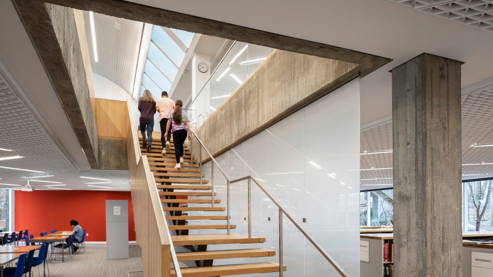 students ascending wood and steel staircase
