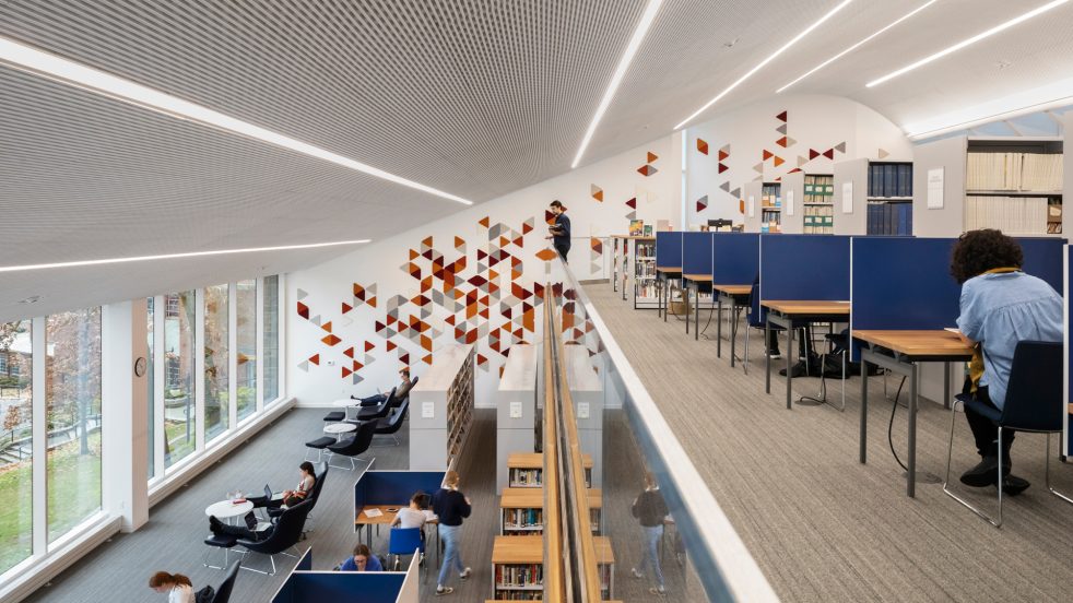 Student overlooks open study space from second floor stacks