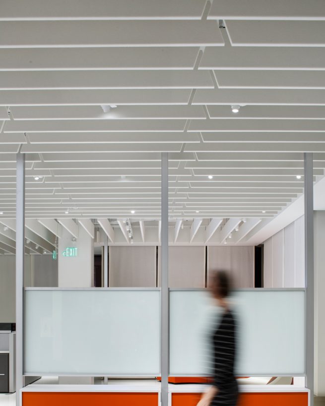 woman walks below white ARO Baffle in Knoll Houston office space