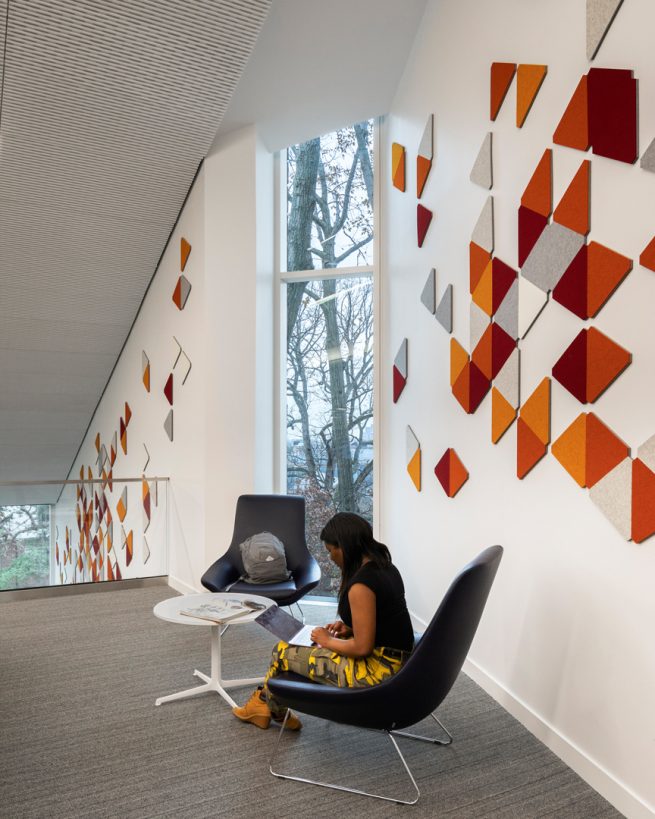 student studies at Tate Library in front of a wall with ARO Block 1