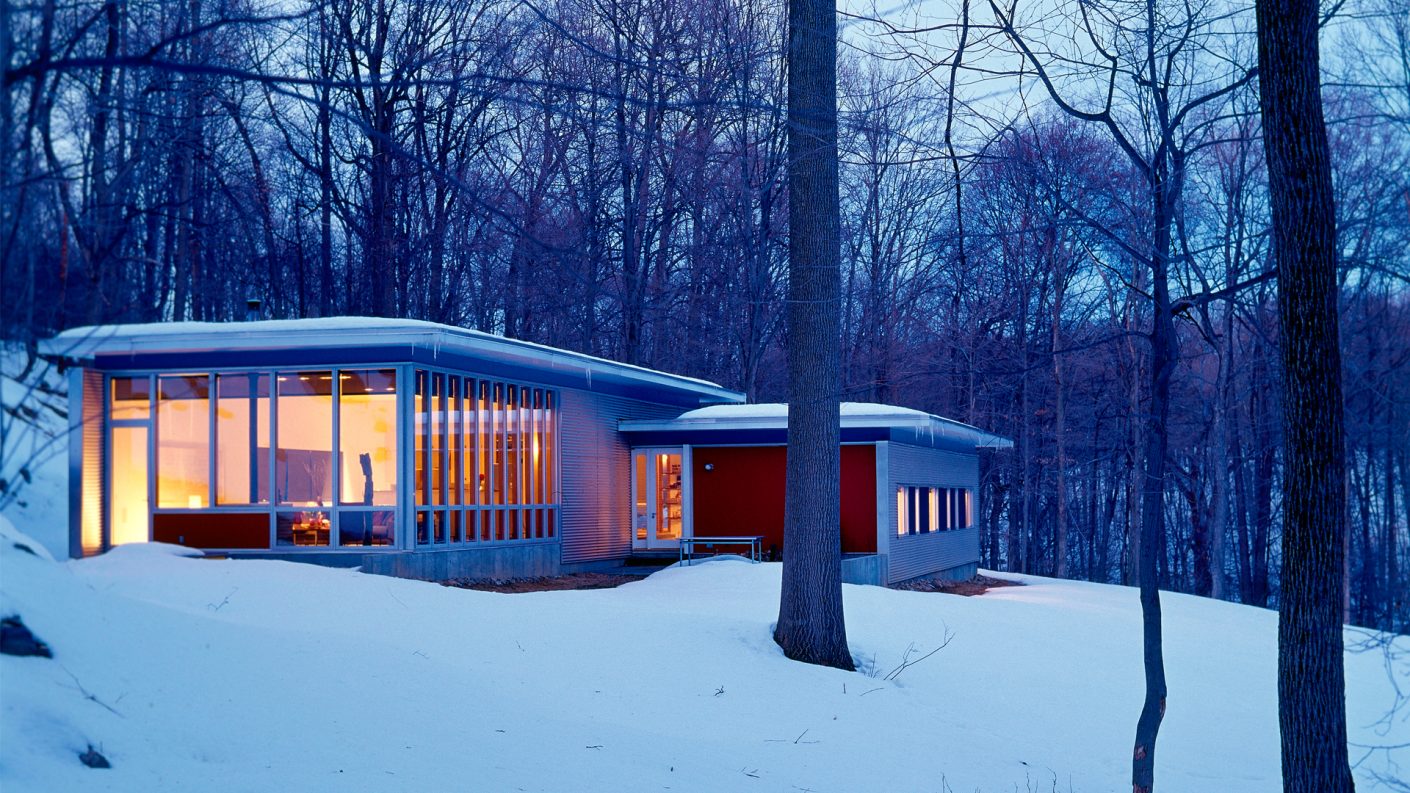 Garrison House in snowy wooded area illuminated at night
