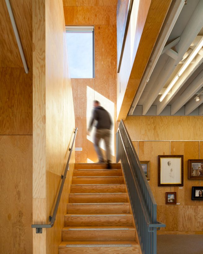 person ascends plywood clad staircase