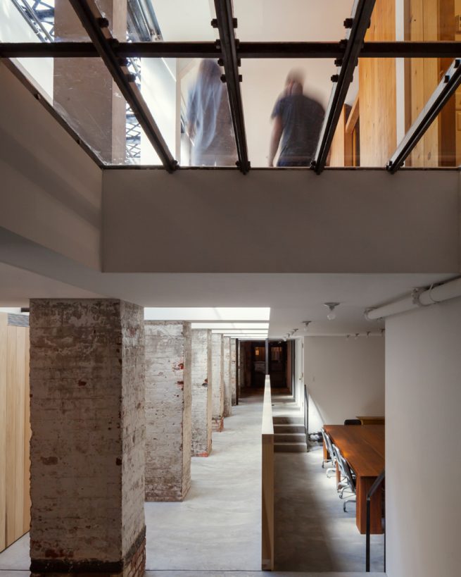 people pass above visible through the glass of the sub-cellar