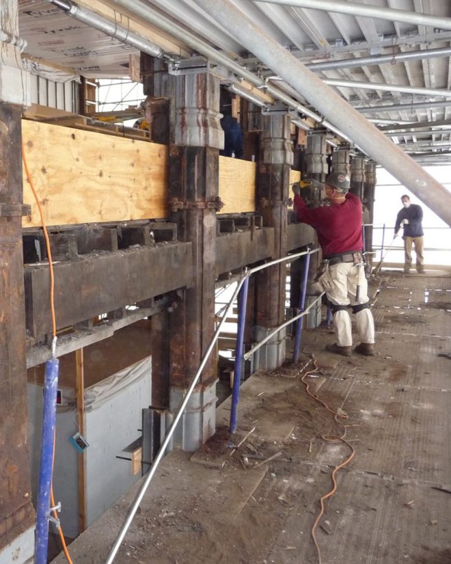 man works on cast iron façade