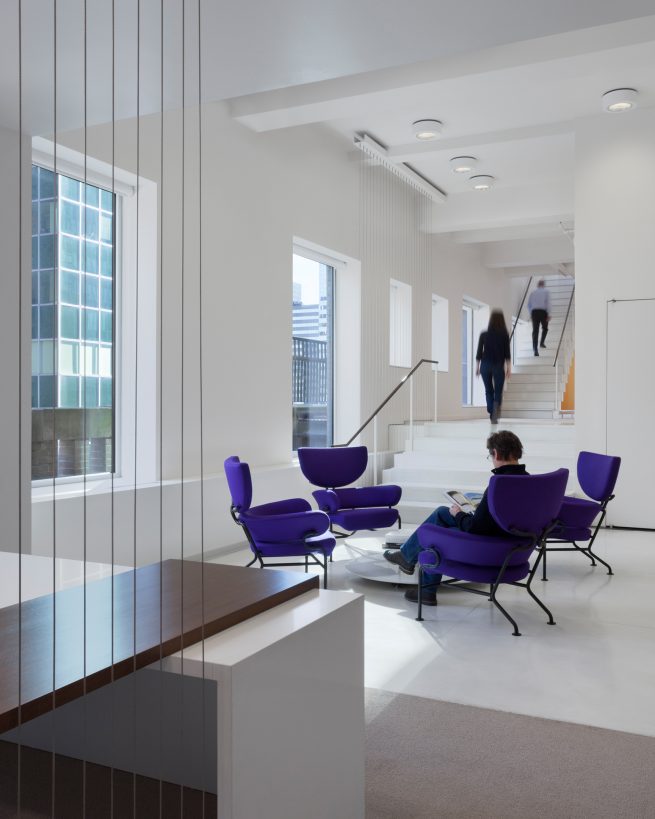 waiting area of purple chairs at base of a staircase