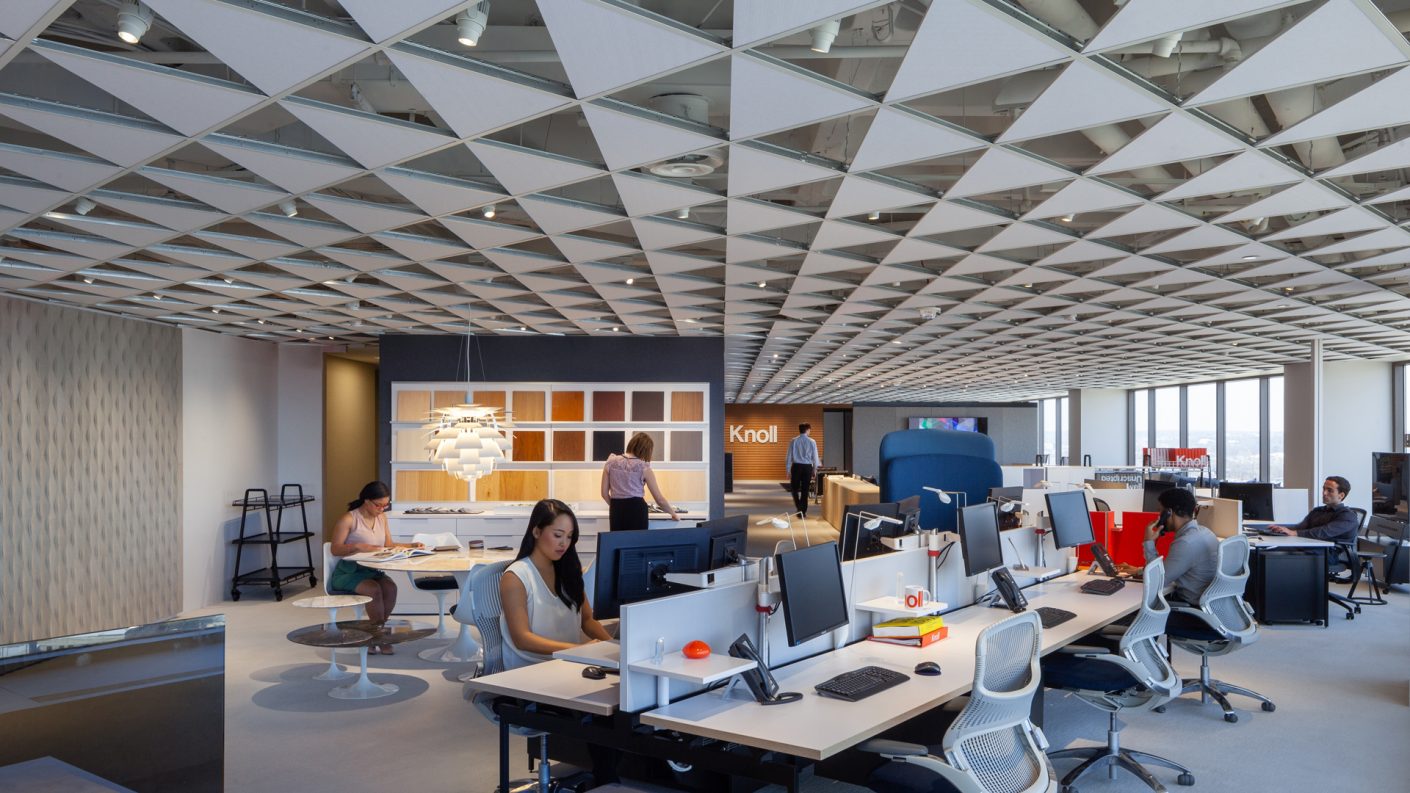 people work at their desks and a materials library in open office area under decorative ceiling installation