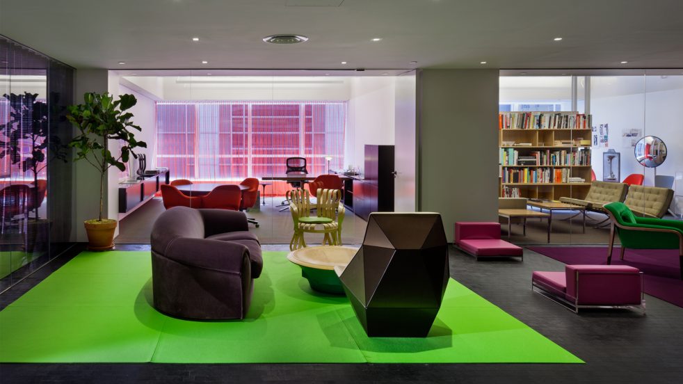 private offices and open seating featuring a bright green carpet and architectural furniture