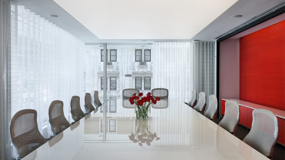 large conference room with floor-to-ceiling windows and an accent red wall