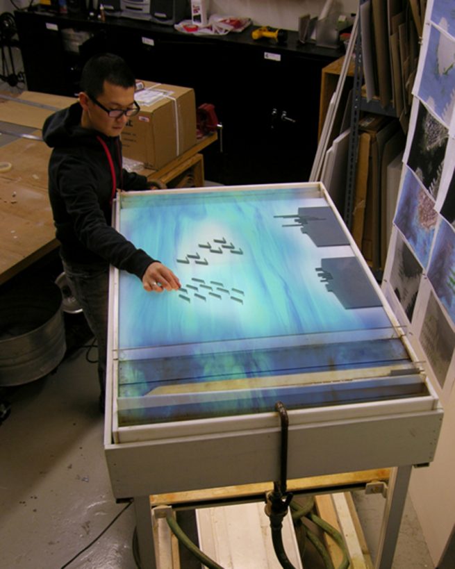 man interacts with water table model