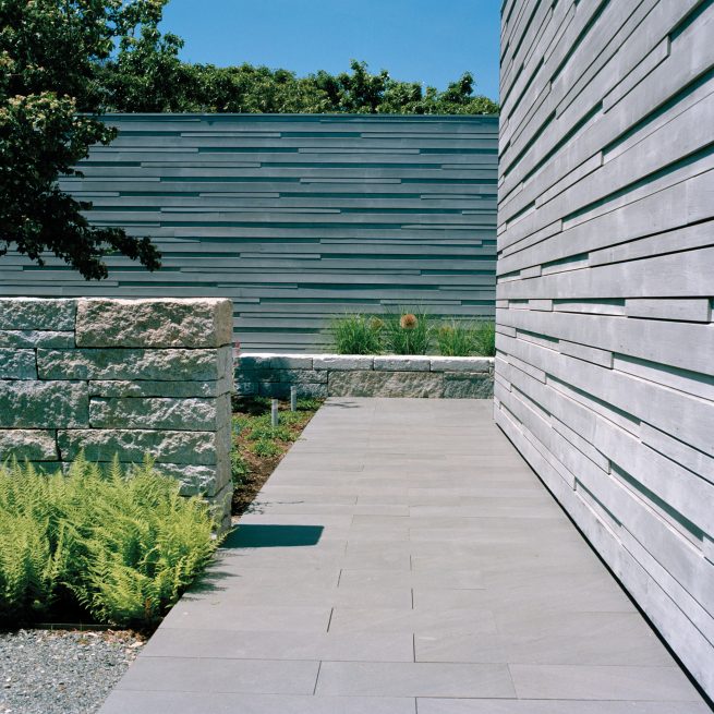 Martha's Vineyard House entry path surrounded by cedar siding and garden