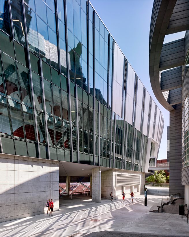 people walk by glass-clad façade