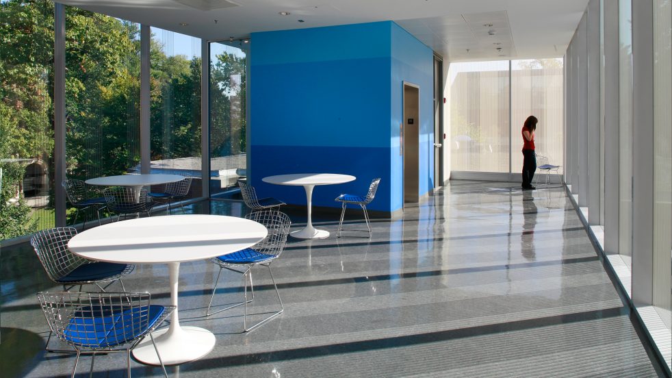 student standing at the end of transparent glazed multipurpose space