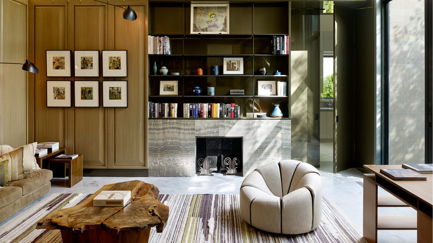 home study in front of fireplace with art displayed above