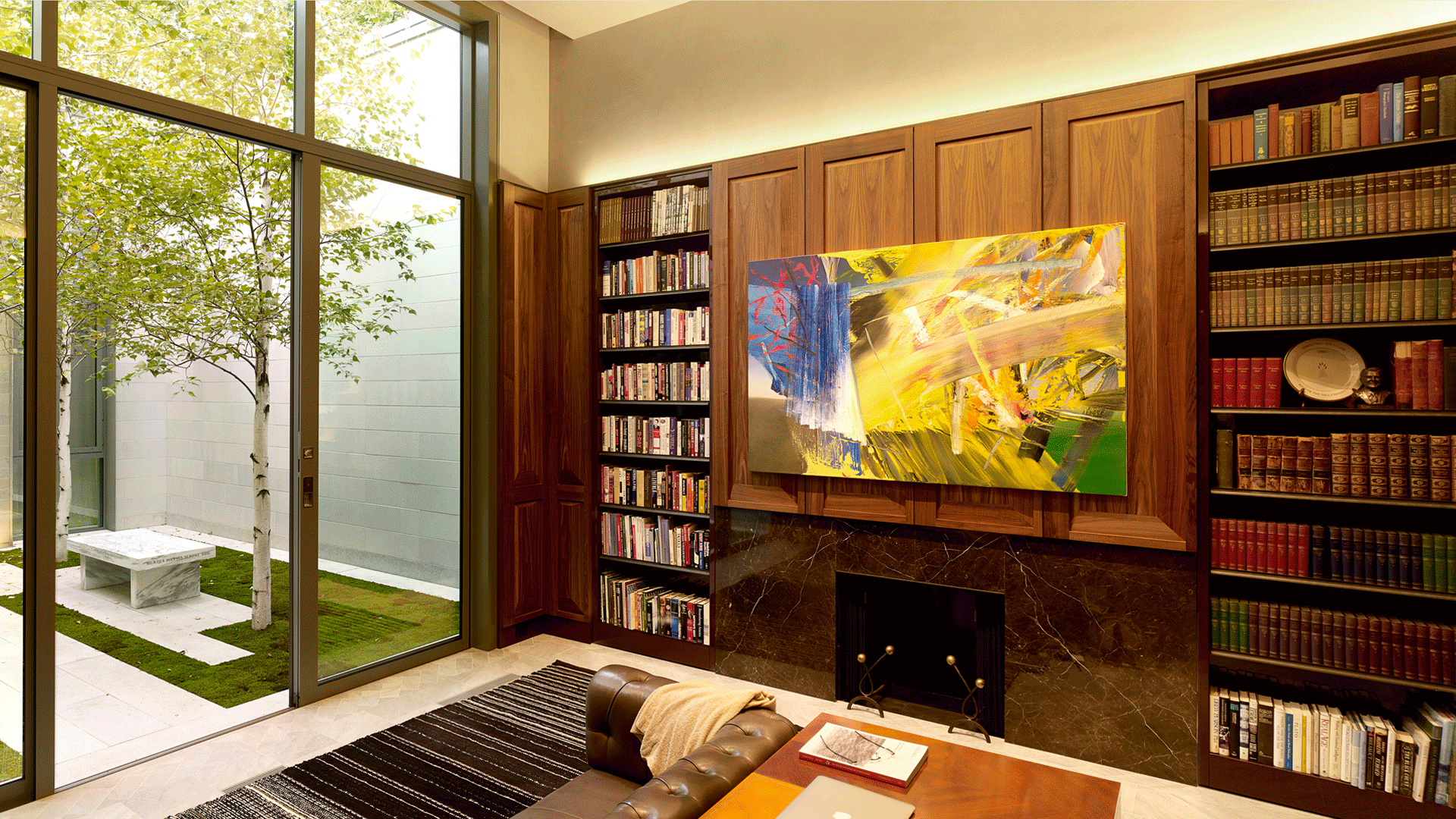 operable bookcases flank a fireplace and painting
