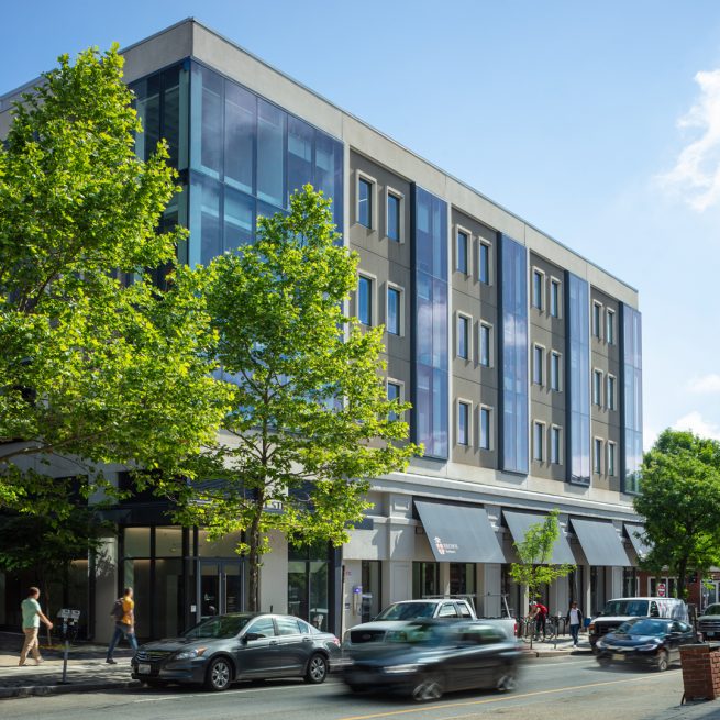 Outside corner of 164 Angell with cars and pedestrians passing