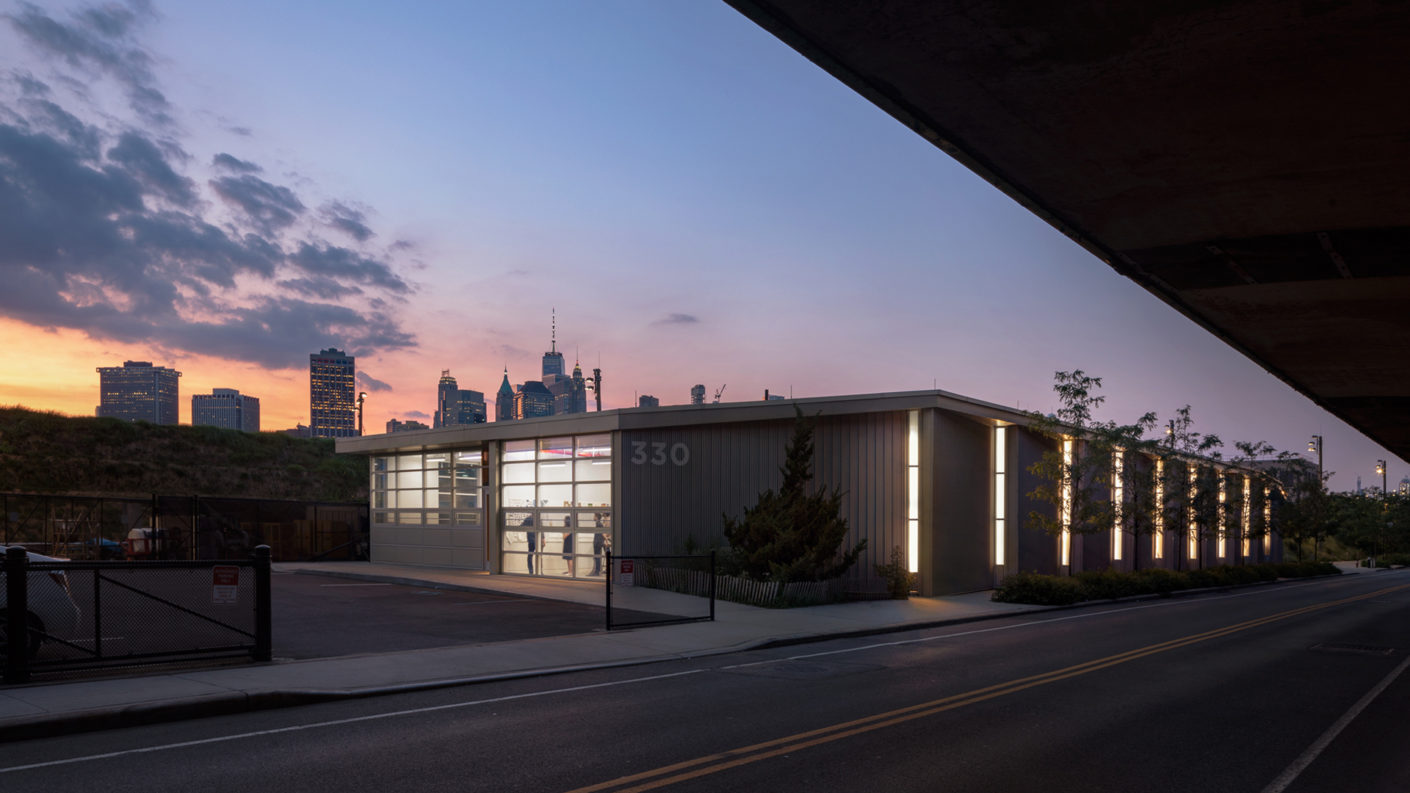 Illuminated Maintenance and Operations building at dusk