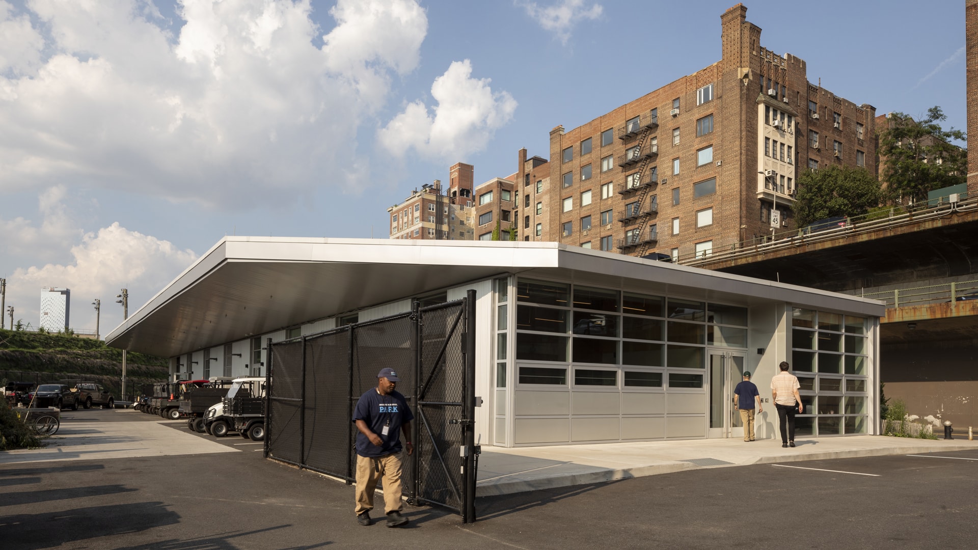 A man exits the storage area through a gate on his way towards the building