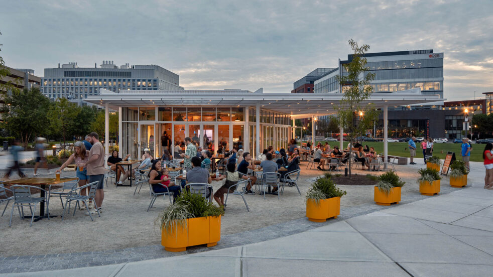 People gather in an outdoor beer garden at dusk.