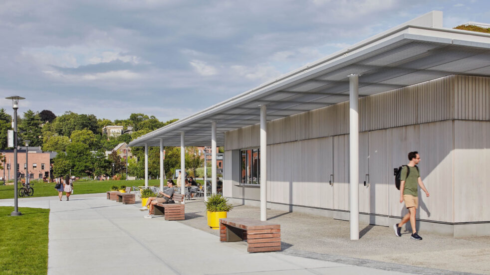 People walk around and enjoy a pavilion in a public park.
