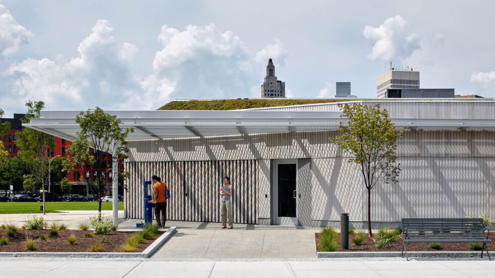 A metal canopy casts dramatic shadows on a park pavilion.