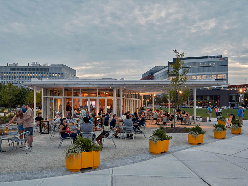 People gather at an outdoor beer garden in a park