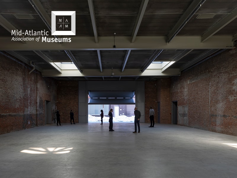 People stand in the east gallery of Dia Chelsea with the metal door open to the street