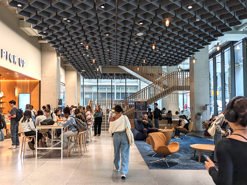 Photo of students sitting and walking around a large ground-floor lobby
