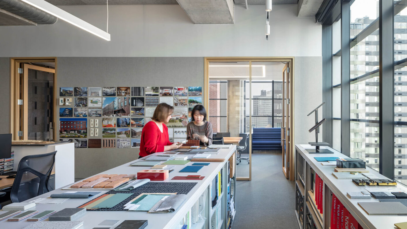 Two people look at material samples in a daylit office