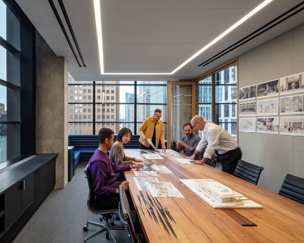 People gathered around a table in a large conference room