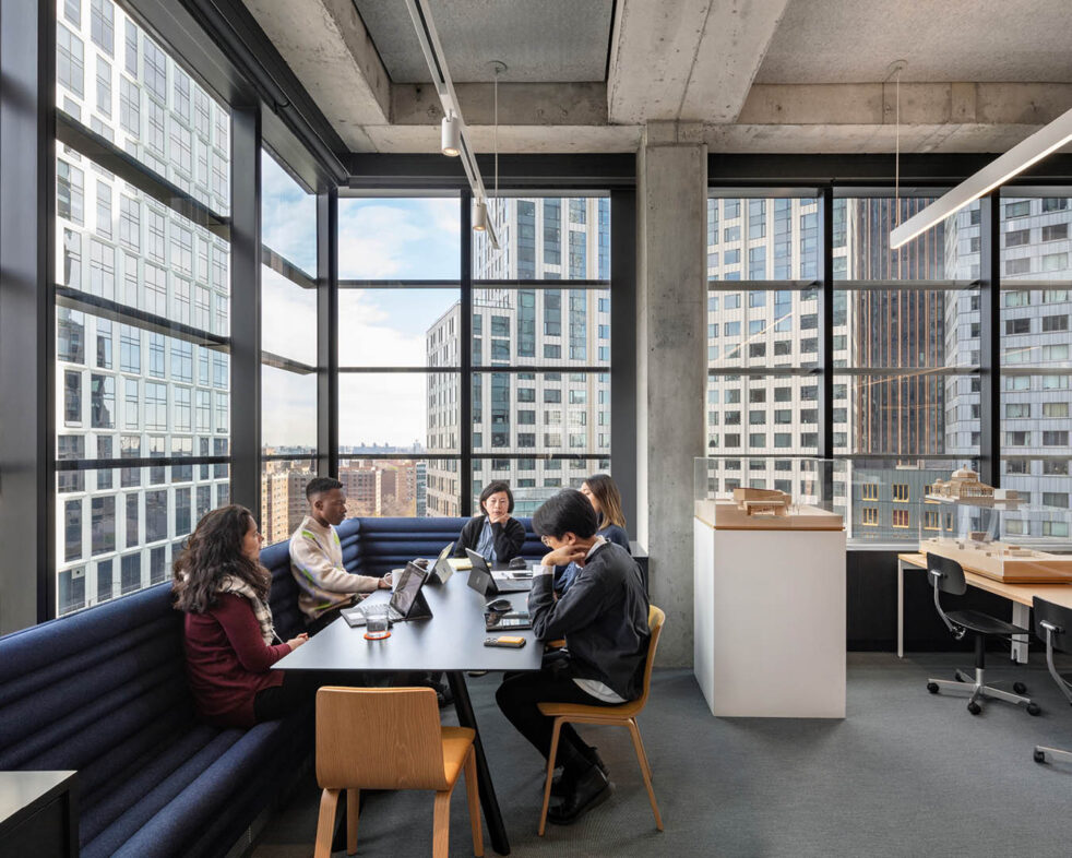 People gathered around a table with views of a city outside